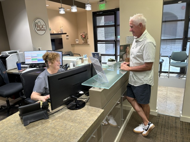 Patient speaking with a team member at the front desk about dental membership plans in Surprise